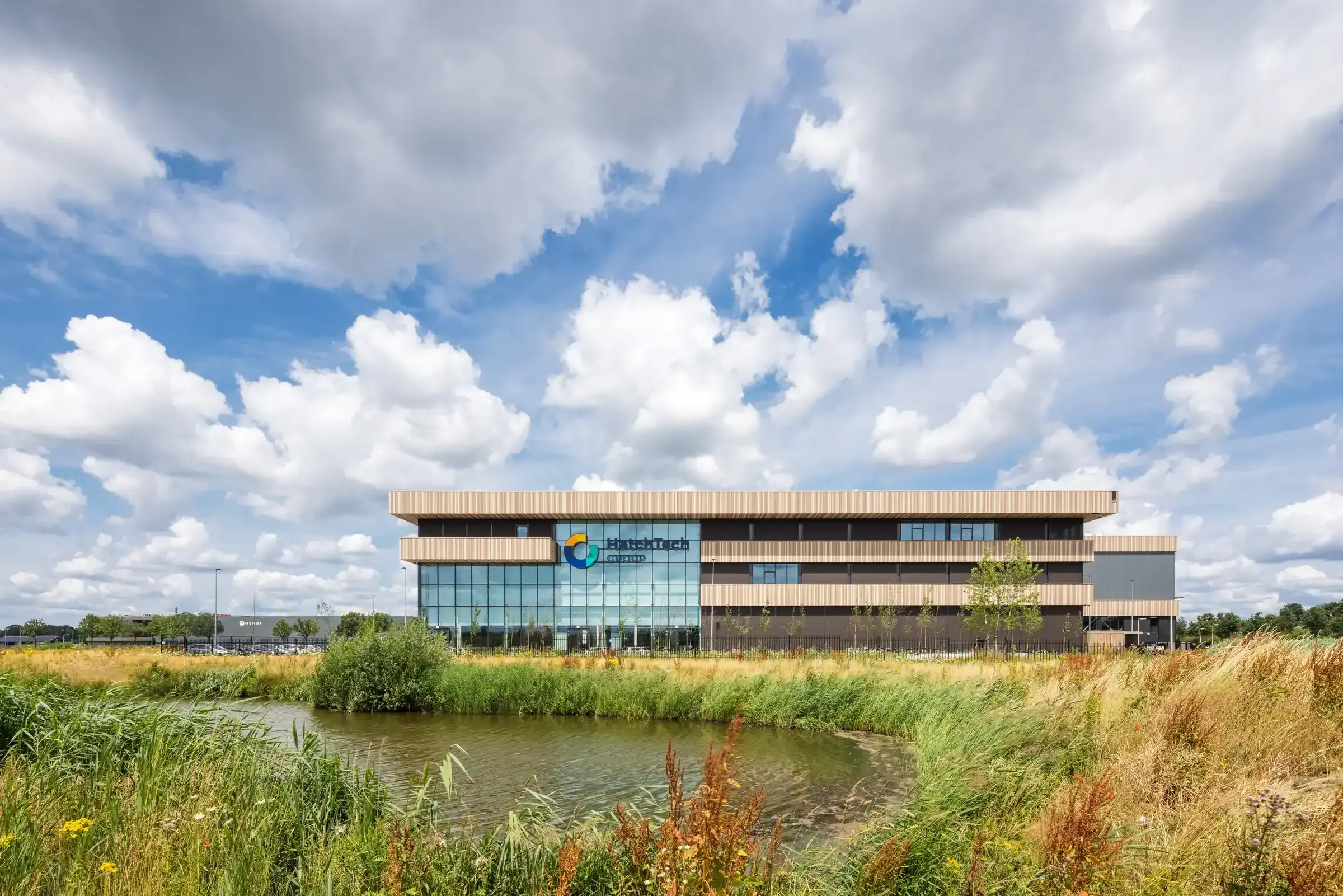 HTHQ Hatchtech Group, Ede – gebouw aan het water, gezien vanaf de natuurrijke oever