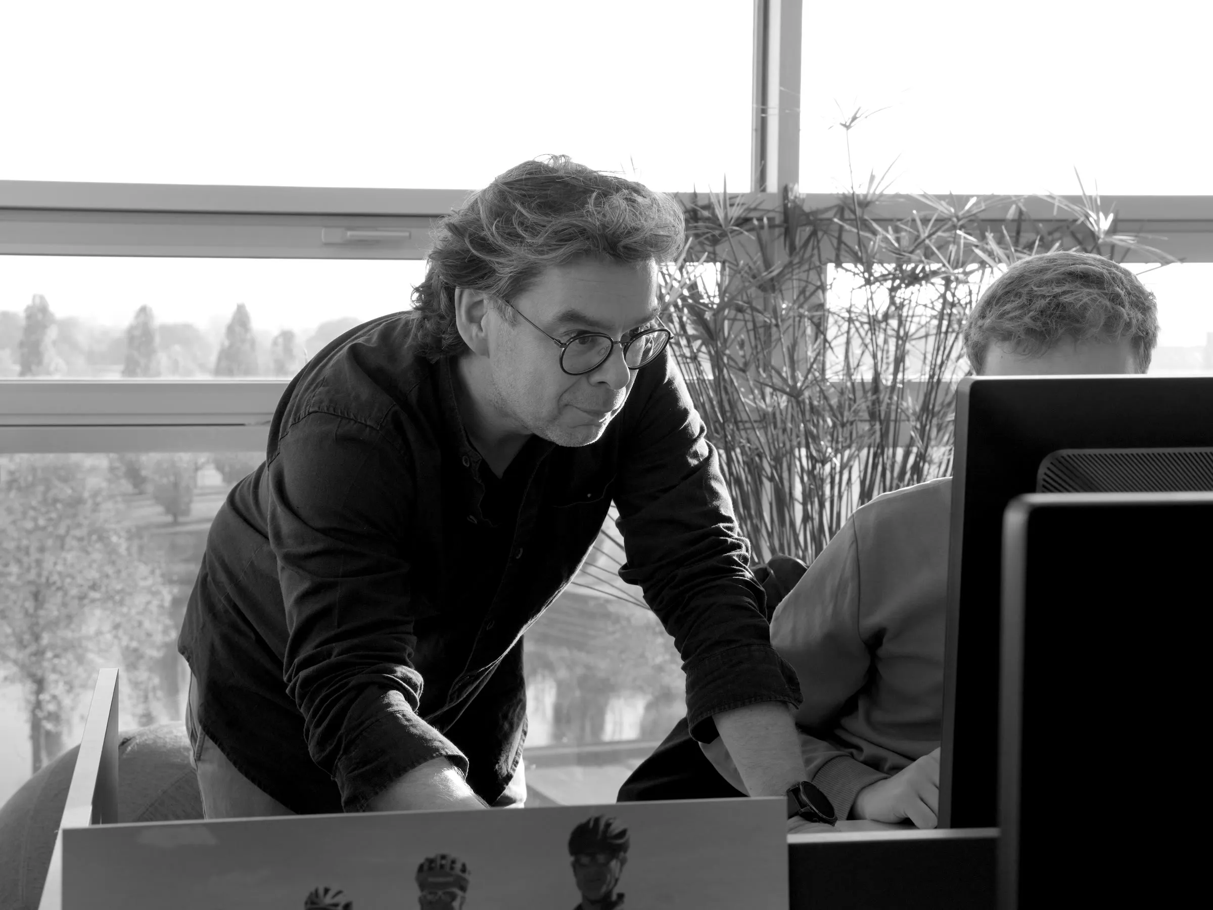 Paul Hoppe kijkt mee op het scherm van een collega