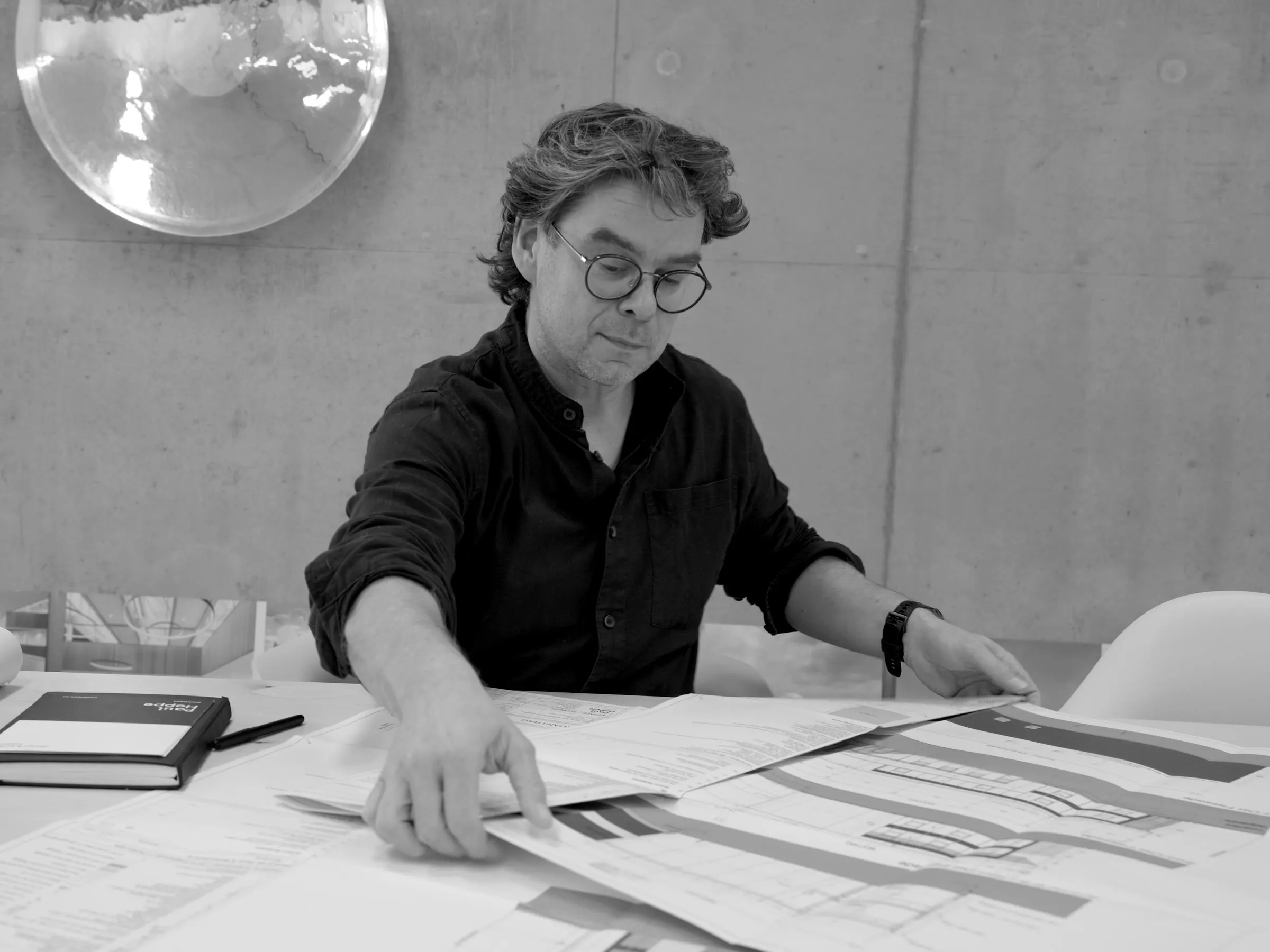 Paul Hoppe bekijkt tekeningen aan de ontwerptafel